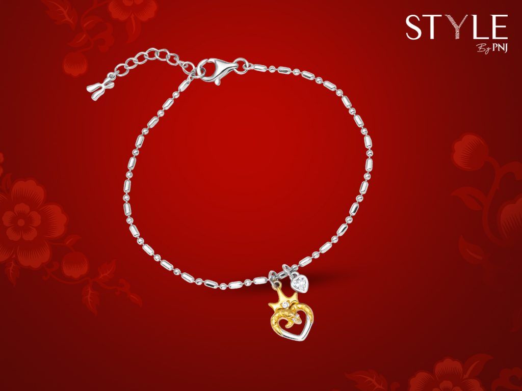 Mặt charm rắn tạo hình trái tim, được điểm xuyết bởi chiếc vương miệng vàng đính đá sáng tạo.